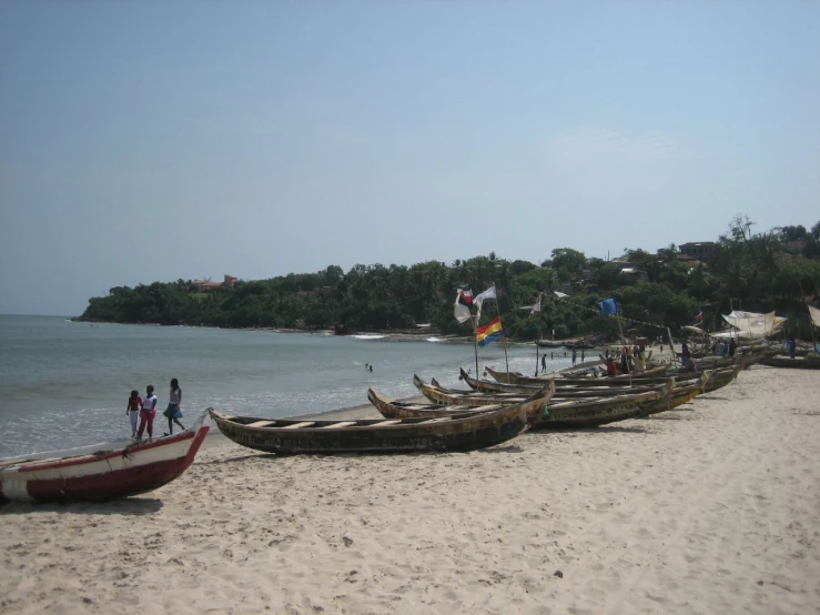 a group of wooden boats sitting next to the ocean