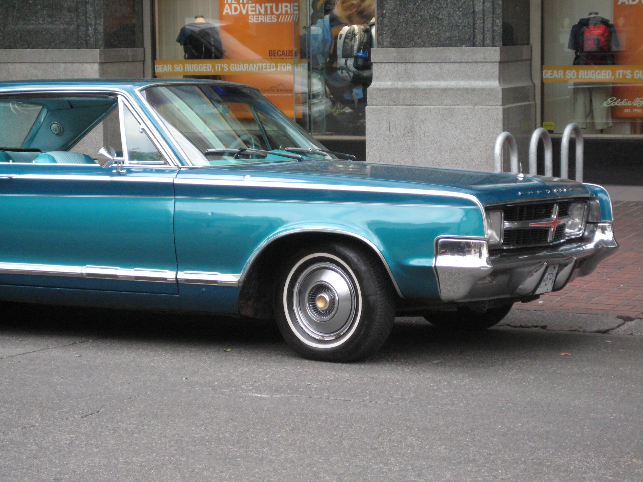 a blue old school car is on the street