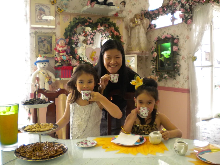 a woman sitting with two s at a table