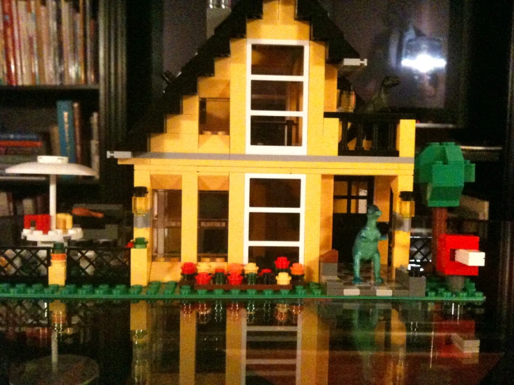 a yellow house sitting on top of a wooden table