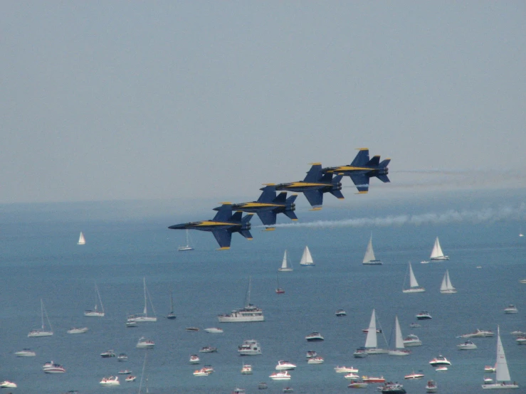 four jets flying high above a large body of water