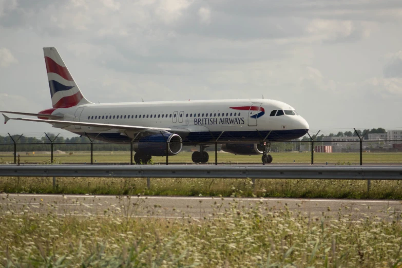 an airplane is sitting on the runway near the grass