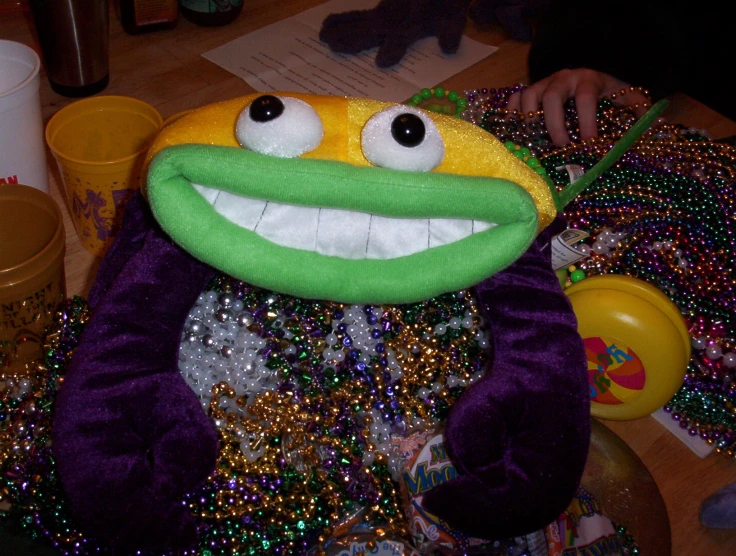 a stuffed animal sitting on top of a table covered in lots of beads