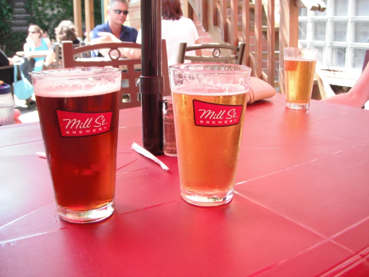 two large glasses of beer sit on a table