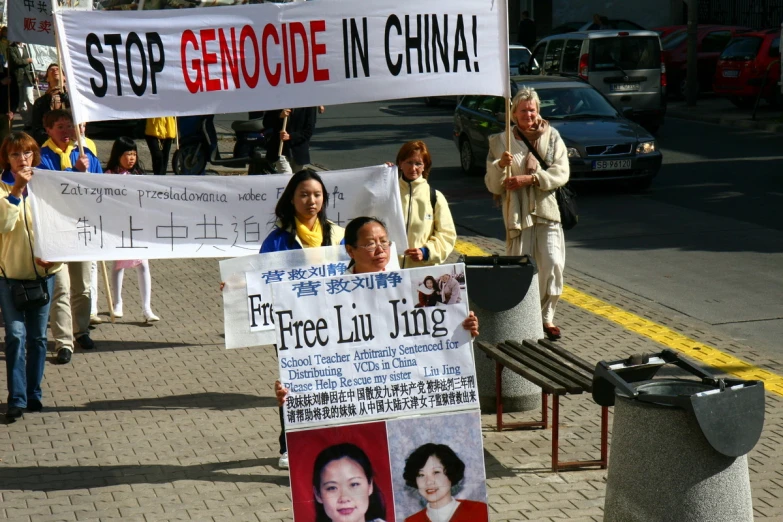 protesters holding placard signs and protesting on street corner