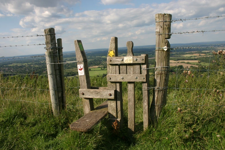 the fence is made of old wood and barbed wire