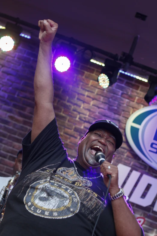 a man in a black shirt holding up a microphone