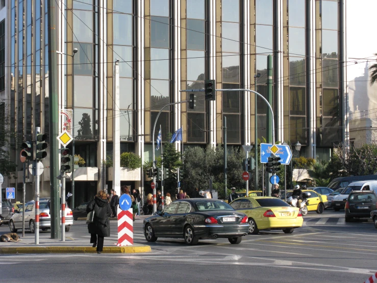 cars driving down a busy street in front of an office building