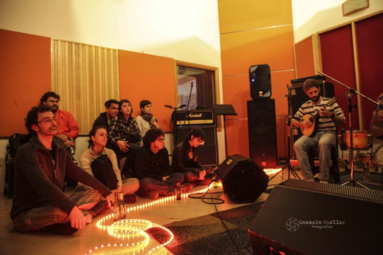 a group of people in a recording room with audio equipment