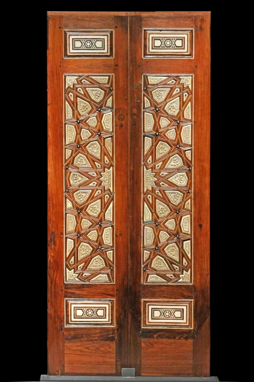 a large wooden door has intricate designs on it