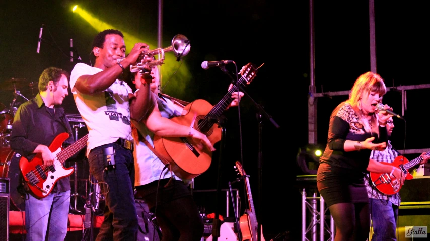 group of people standing on stage and playing instruments