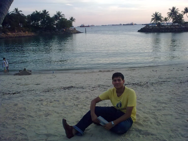 a young man is sitting on the beach