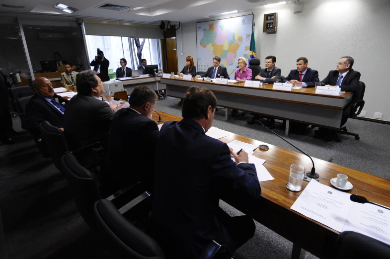 a large group of business people sitting in front of a conference table