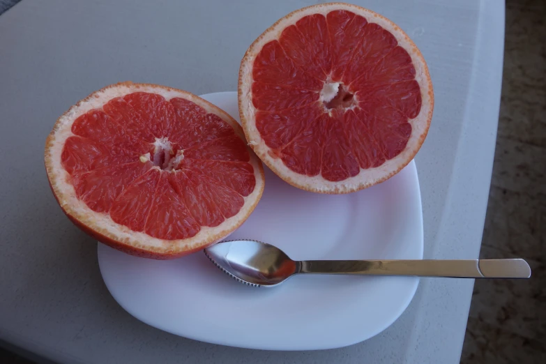a gfruit cut in half sitting on a plate