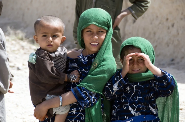 there are three children wearing muslim headscarves