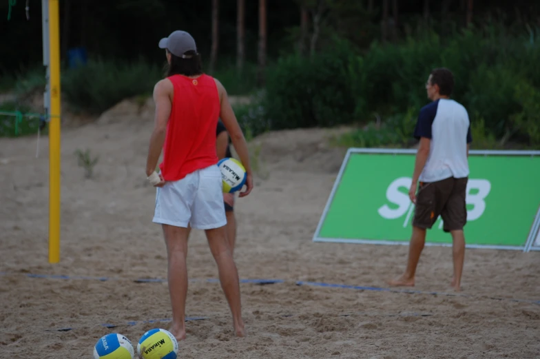 two men are playing beach volleyball on the sand