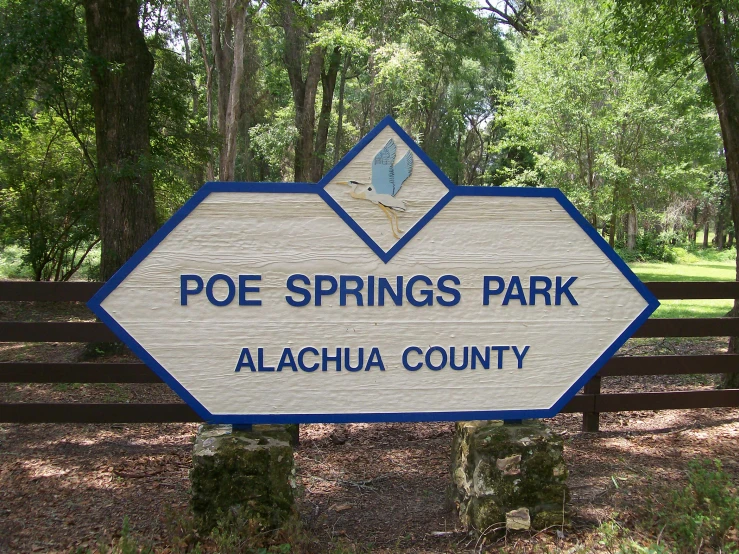 a sign is on a wooden fence in the woods