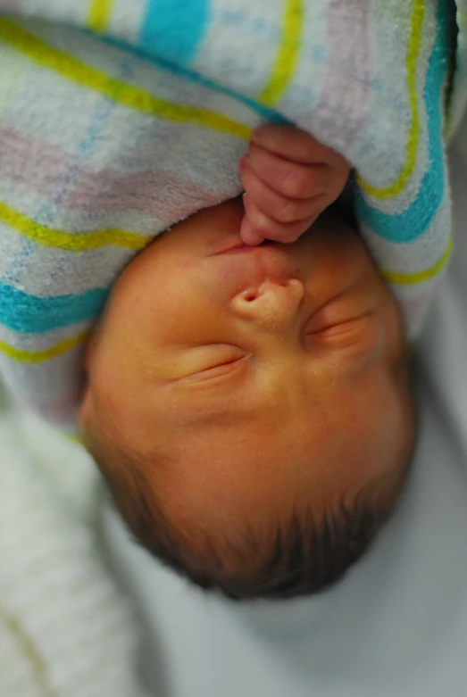 a newborn baby is wrapped up in a blanket