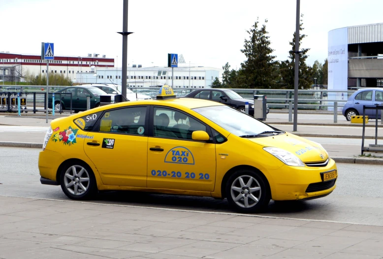 the yellow taxi is traveling down the street