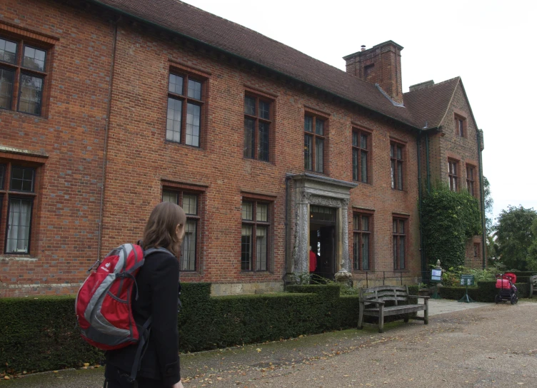 the woman stands in front of an old building