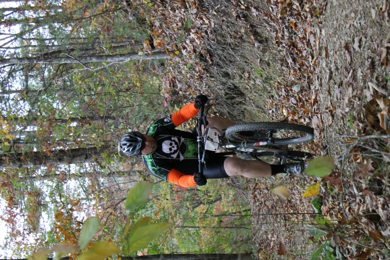 a biker in black jacket riding on forest path