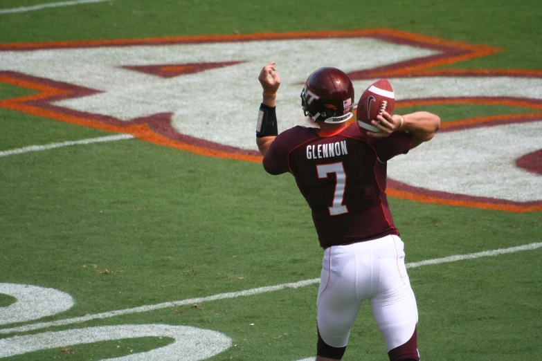 football player with maroon uniform about to throw a ball