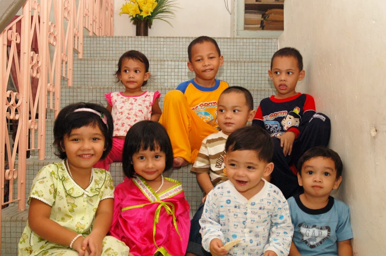 a group of children sitting next to each other on steps