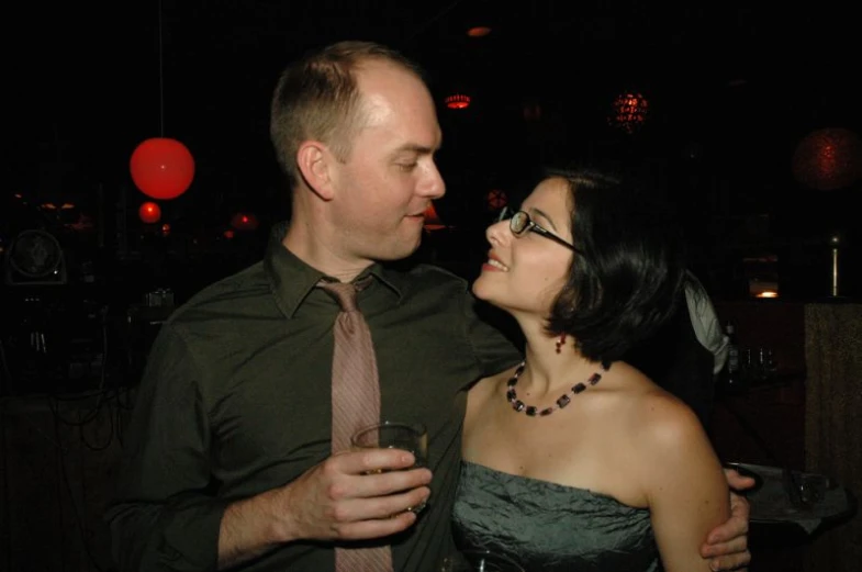 a man and woman dressed in ties and evening gowns pose together