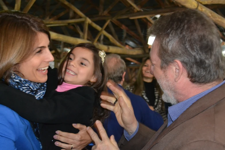 a  is being hugged by her father and mother