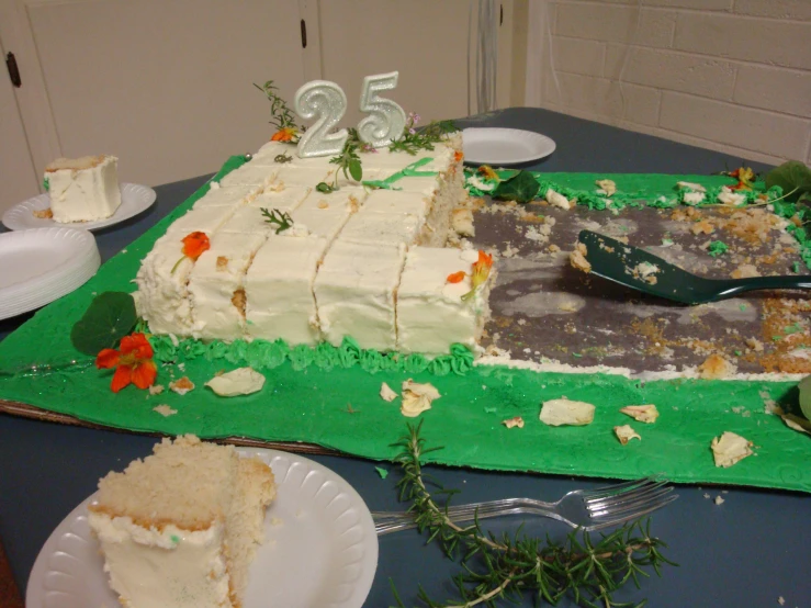 a cake decorated with flowers, leaves and a half eaten cake