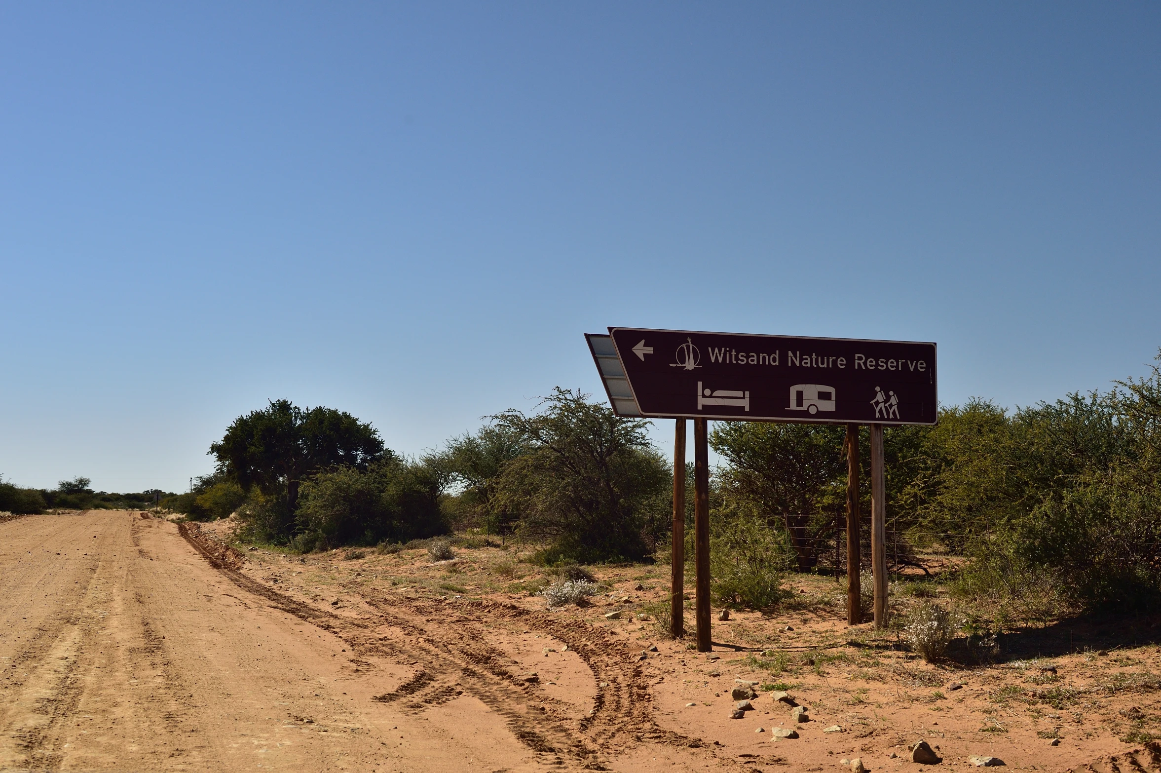 a dirt road is a sign for the wildlife park