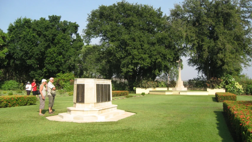 three people walking toward a monument in a park