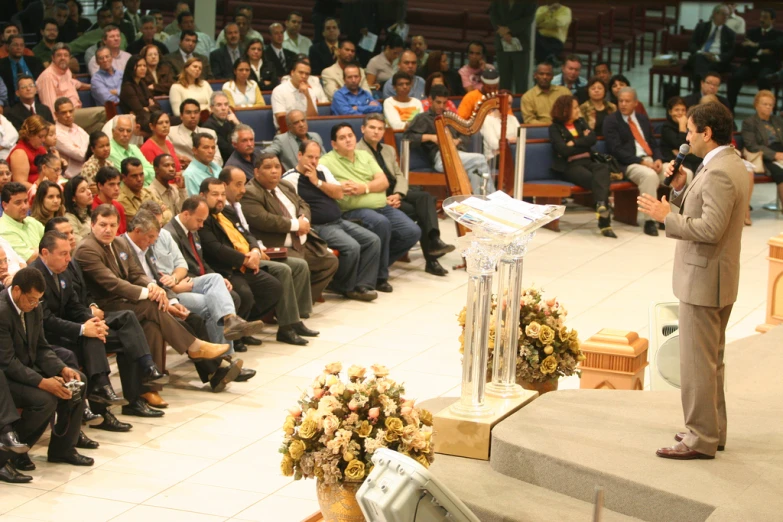 an audience watches a speaker speak at a conference