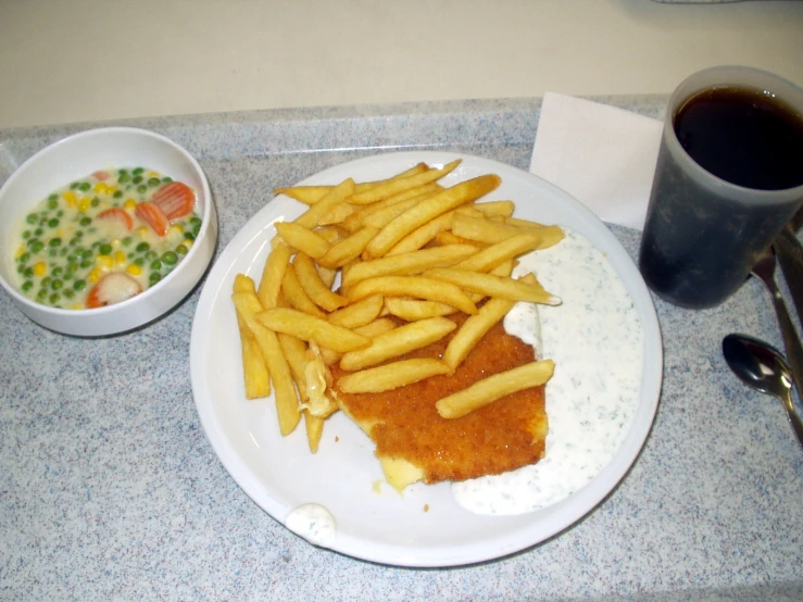 a plate of french fries next to a cup of tea