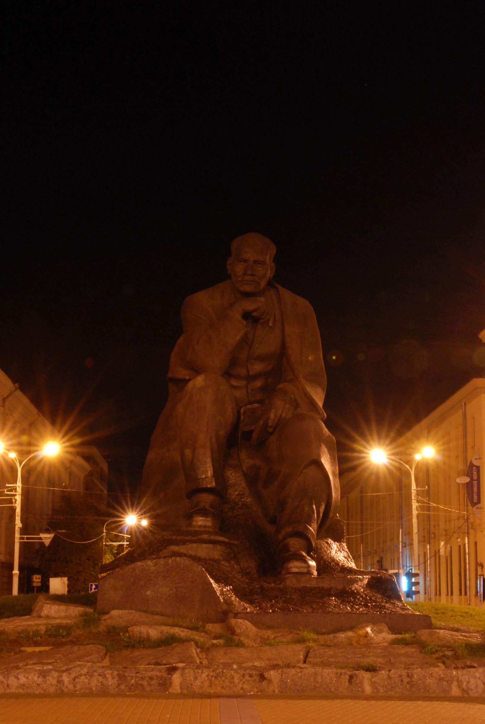 the large statue is situated in front of the buildings