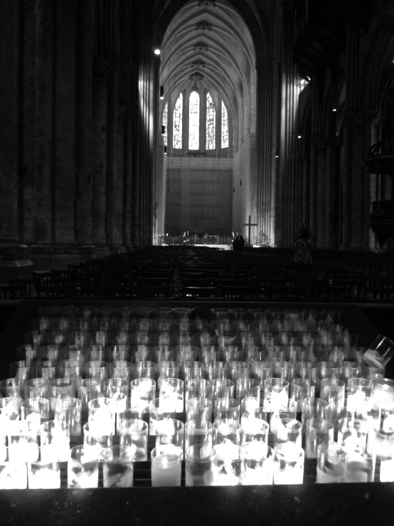 a dark church with rows of candles lit up