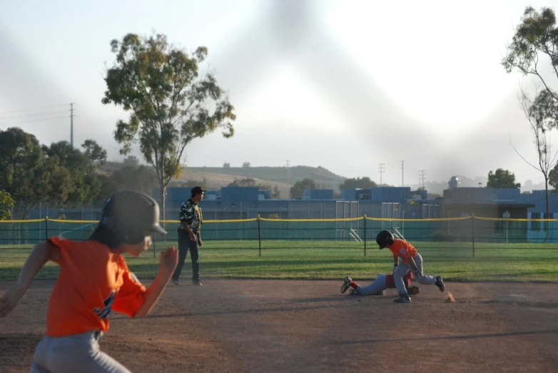 two children play baseball on the field during a game