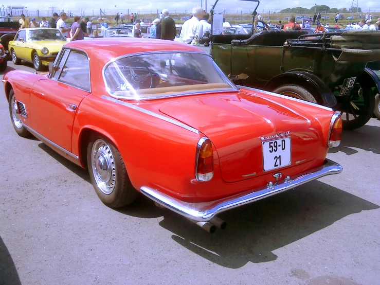 the vintage orange car is in line for a show