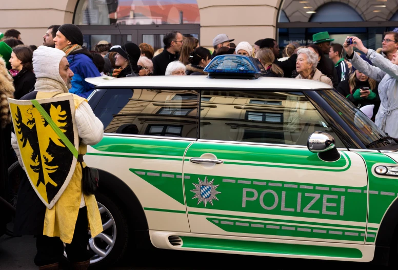 many people are celeting in a parade where there is a police car