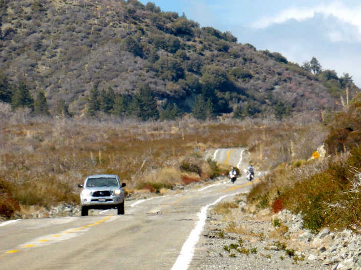 there are two people on motor bikes that are traveling down the hill