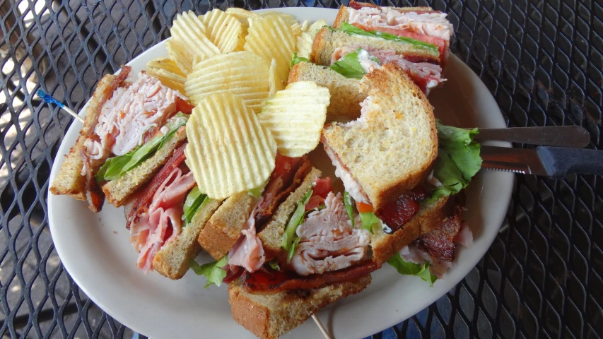 an up close picture of a sandwich on a plate with chips