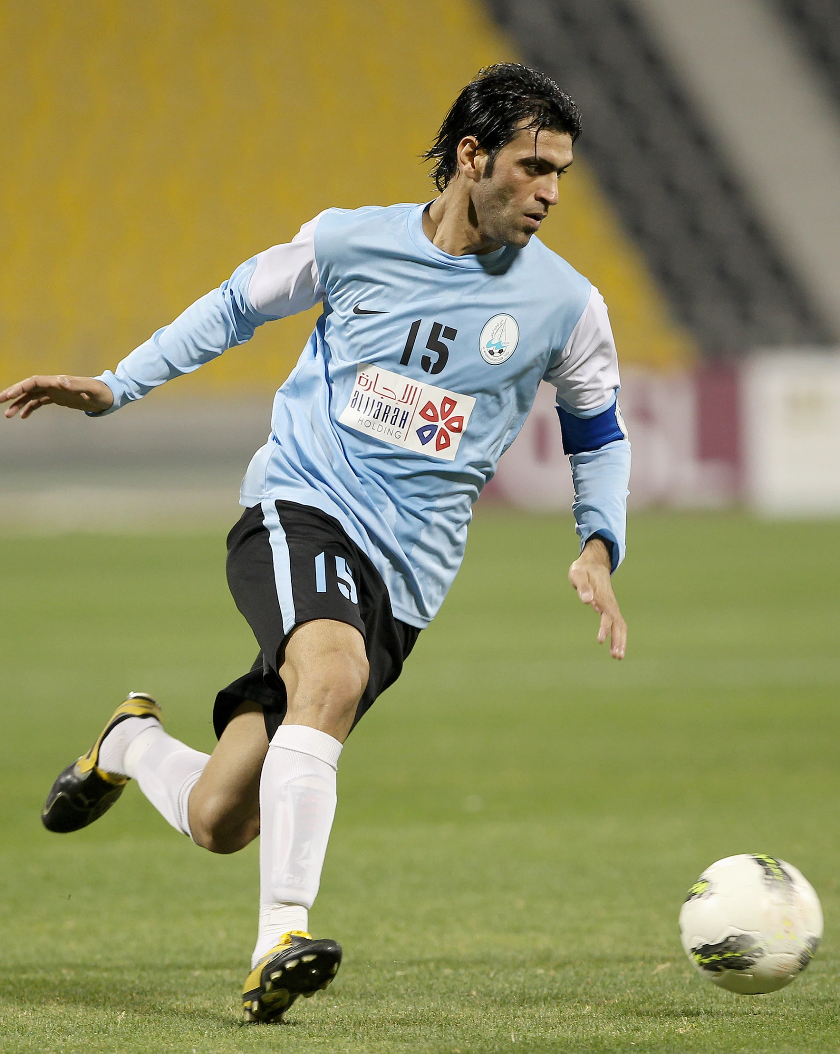 a man kicking a soccer ball on top of a field