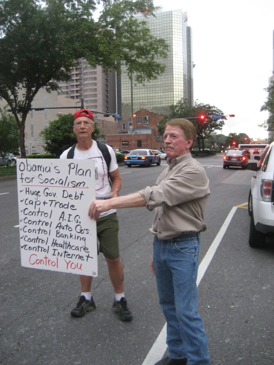 two men in the street with a sign for a city