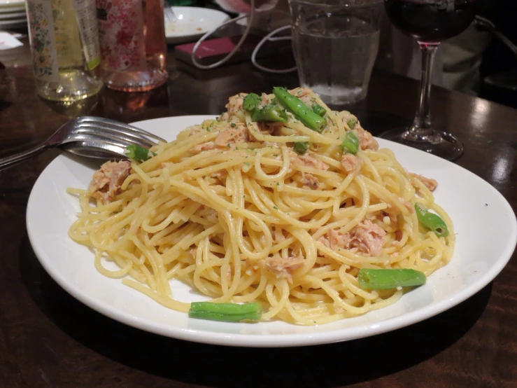 a plate with spaghetti and meat topped with peas