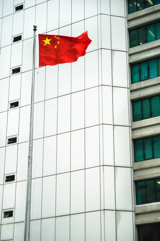 a chinese flag flies in front of an office building