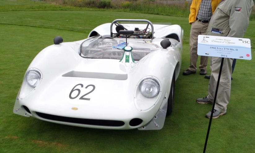 a man standing next to a white sports car