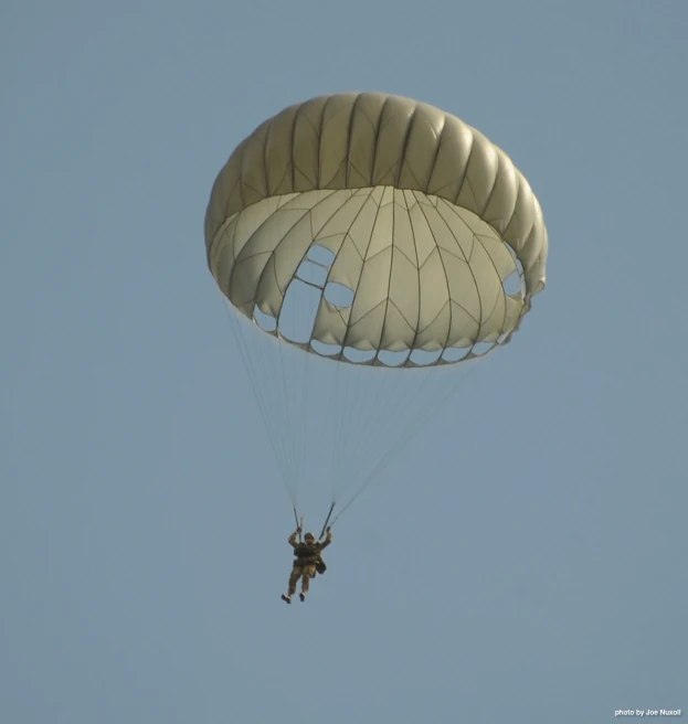 the person is parasailing in the clear blue sky