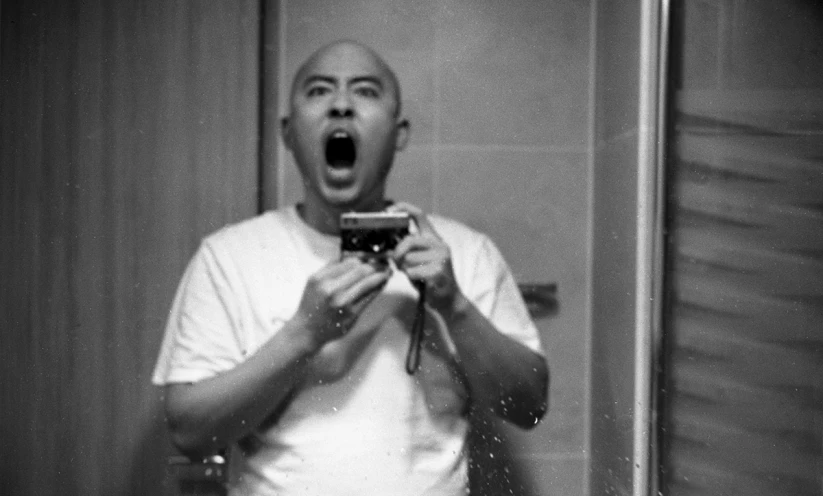 a man making a surprised face in front of a mirror