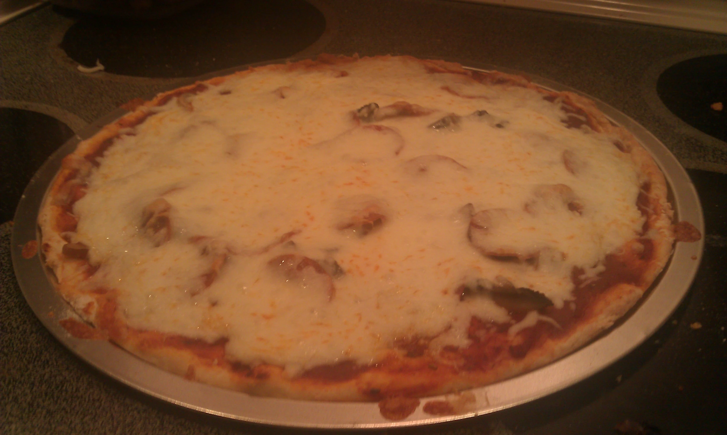 a pizza sitting on top of a pan covered in cheese