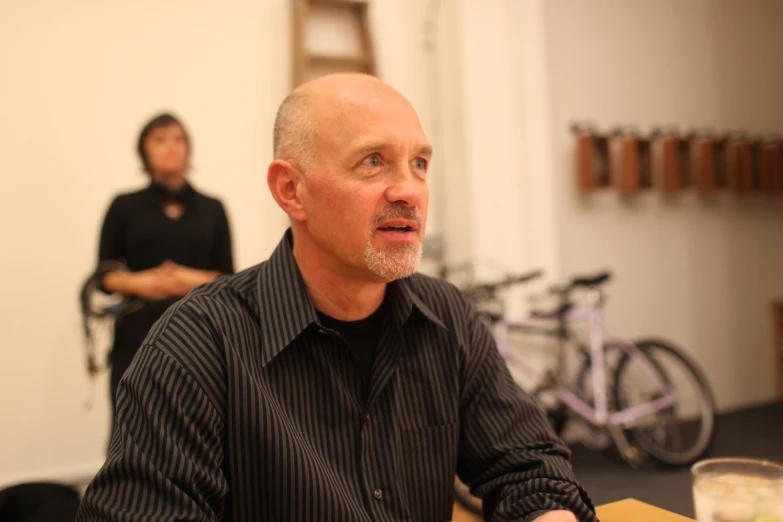 a man sitting at a table with a glass of wine